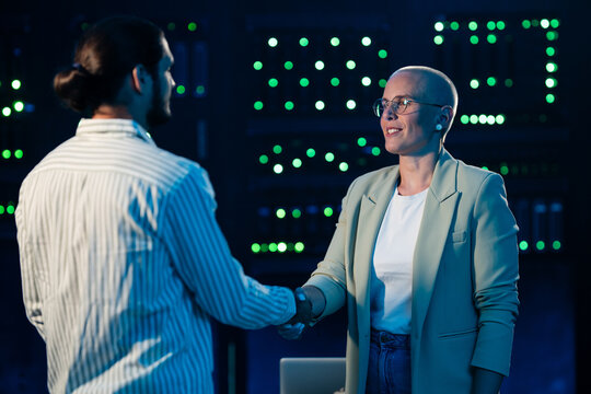 It professionals shaking hands in server room