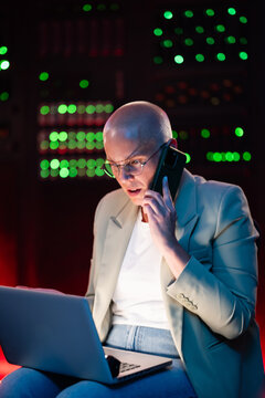 Data scientist working in server room talking on phone