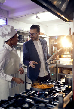 Cook in Professional Modern  kitchen, restaurant concept. Teacher explane about meal preparation.