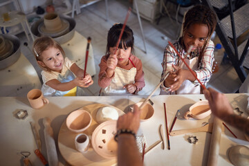  smiling children with brush on art class in school. Creative, hobby ,workshop  concept © luckybusiness