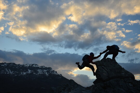 Helping Hand on a Mountain Climb, Teamwork and Shared Success