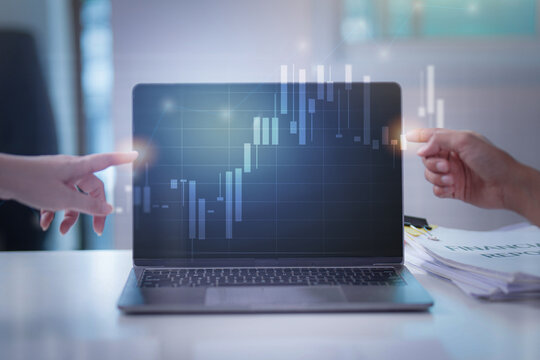 Two hands pointing at stock market growth chart on laptop screen during financial review