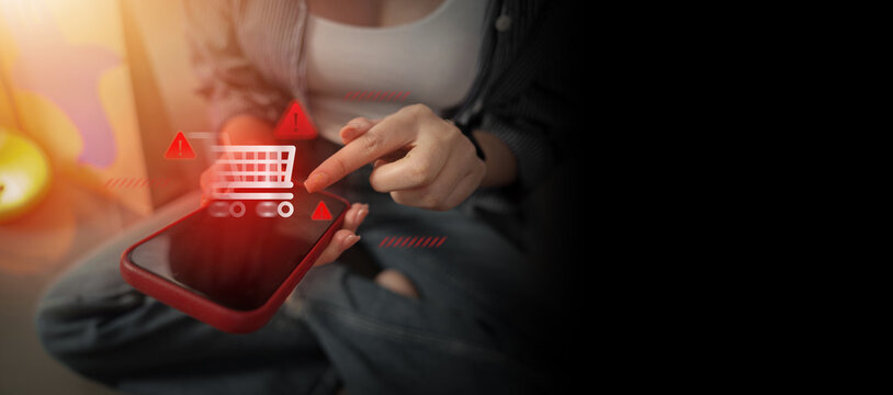 Entrepreneur using smartphone with shopping cart and warning icon for online scam concept
