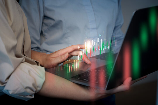 Business team analyzing stock market candlestick chart overlay on laptop for investment trading