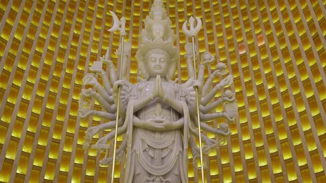 A Majestic MultiArmed Statue in a Radiant Golden Sanctuary Surrounded by Natural Beauty