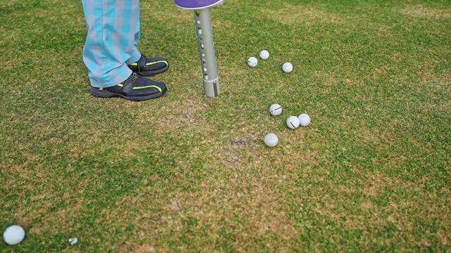  Golf Ball Shagger tube. A man collects golf balls from the course at the end of a game