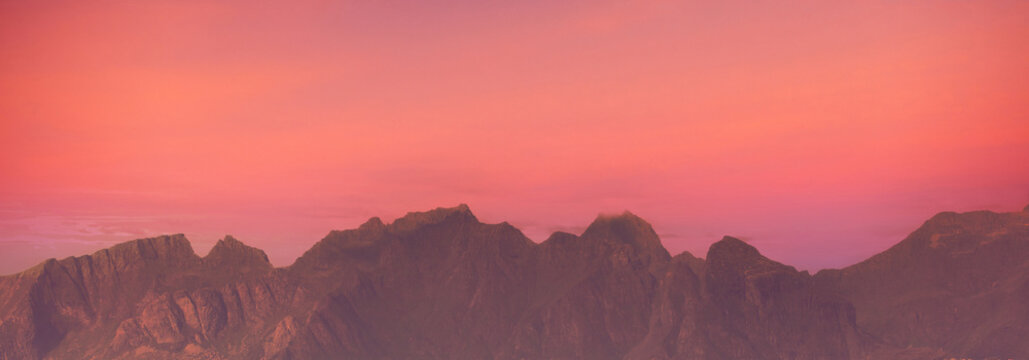 Silhouette of mountains against a red sunset sky