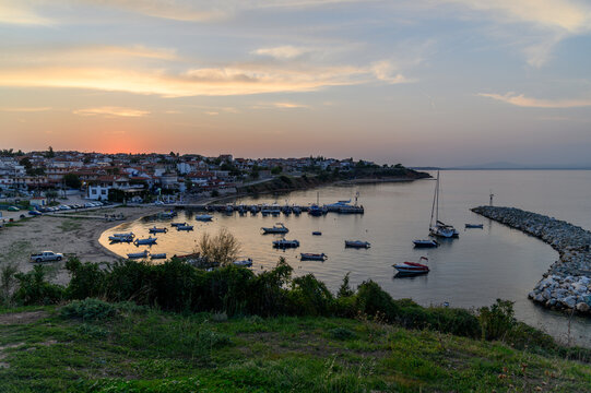 Nea Fokea harbour at sunset from above with the village, moored boats and the stone breakwater, Kassandra, Chalkidiki, Greece
