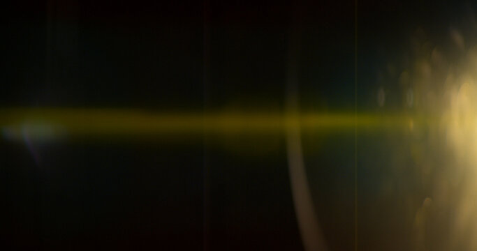 Golden anamorphic lens flare overlay featuring a warm horizontal light streak, realistic optical reflections and subtle glow on a black background. Premium VFX asset for compositing and film editing.