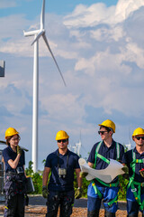Fototapeta premium A commissioning team in navy suits and yellow hard hats check disconnector positions against the diagram inside the wind farm grid substation in crisp blue sky daylight at a wi image 6003.