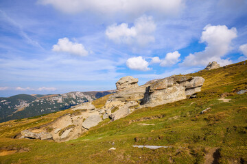 Fototapeta premium A beautiful mountain landscape in the Bucegi Mountains (part of the Carpathians in Romania), featuring various rock formations shaped by the erosion of time, wind, and mountain rains.