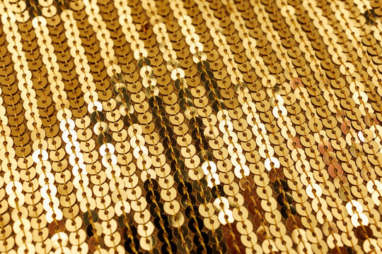 Gold sequin fabric texture with shimmering metallic pattern