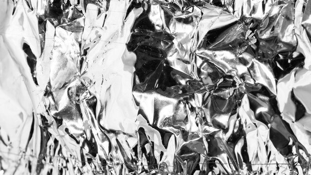 Crumpled silver foil as background, closeup view