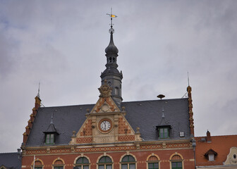 Obraz premium Historisches Rathaus und angrenzende Gebäude am Marktplatz von Dahlen mit parkenden Autos vor bewölktem Himmel – Landkreis Nordsachsen, Sachsen, Deutschland 