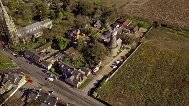 Moulton, Lincolnshire. Aerial drone orbit rotate around the village church and Windmill; the tallest windmill in the UK.