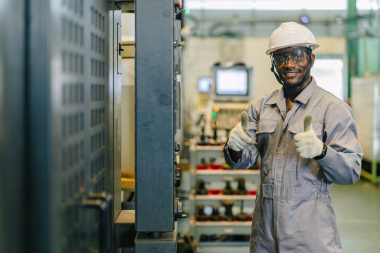 Portrait Happy Smiling Black Engineer Operating CNC Machine in Metal Part Industry Factory Thumbs up
