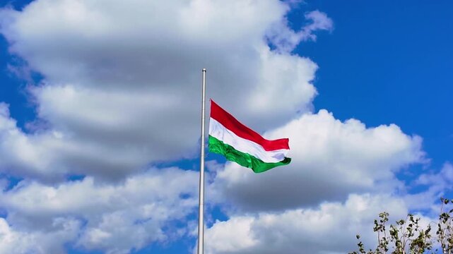 Hungarian Flag Waving Gracefully Against a Bright Blue Sky