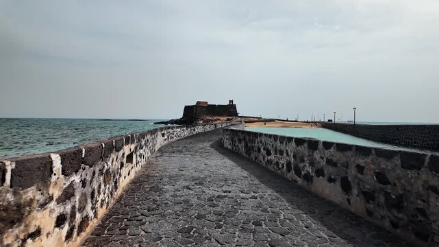 Slow motion push shot of the Puente de las Bolas causeway to Castillo de San Gabriel, Arrecife, Lanzarote
