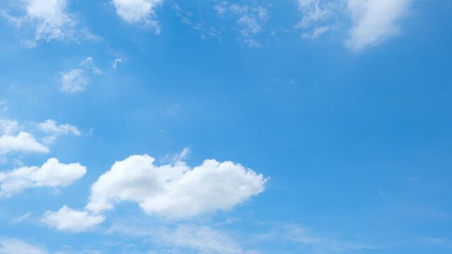 A blue sky cloud timelapse video captures bright cumulus clouds and scattered altocumulus drifting in gentle winds across a clear blue atmosphere, reflecting sunny daylight and fair weather. 4k.
