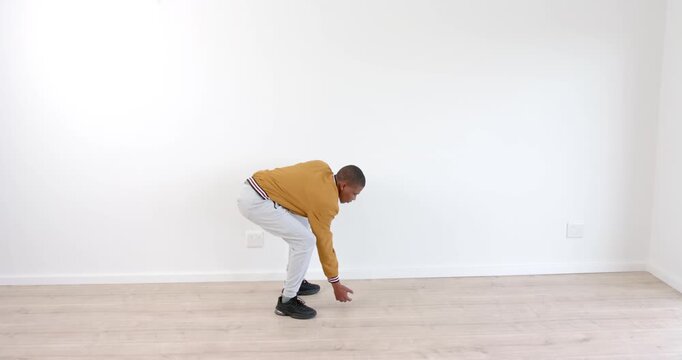 Young boy in casual outfit practicing mime skills against white wall indoors