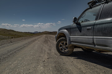Low angle side view of a dusty off-road 4x4 suv car parked on a remote gravel road, overlanding adventure concept © ANDREY