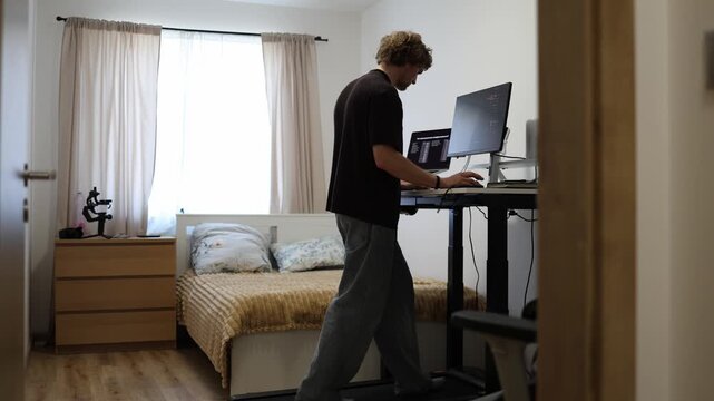 Remote worker walks on a treadmill while managing tasks across multiple computer screens creating an active workspace that replaces long hours of sitting with daily movement