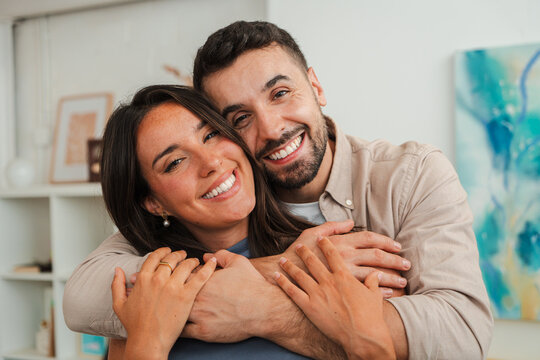 Warm portrait of a smiling couple wrapped in a tight embrace, communicating trust and affection. The moment emphasizes shared joy, support and closeness, ideal for family life and relationships.