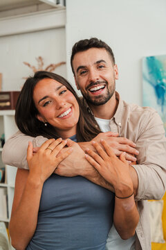 A warm candid portrait of a smiling couple sharing a heartfelt hug, showcasing affection and connection. Their embrace conveys comfort, happiness, and a sense of teamwork in everyday love and trust.