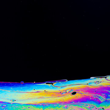 Abstract iridescent soapy surface pattern with copyspace