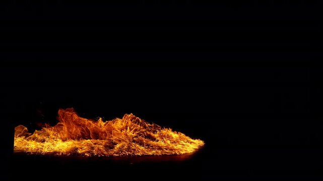 Small fire explosion with glowing sparks and embers isolated on a black background. Dynamic flames and combustion effects captured in high detail for dramatic visual impact.