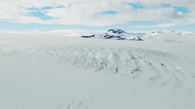 Vatnajokull ice cap in southeast Iceland with vast snowfields, glacier crevasses and isolated volcanic nunataks rising above the ice within Vatnajokull National Park, aerial drone shot