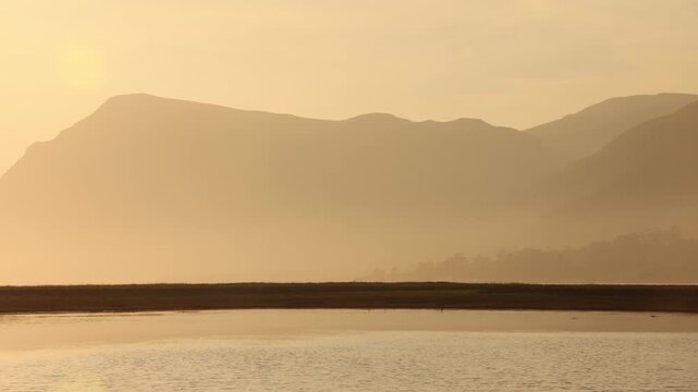 pale sunset over lagoon and reflection of klein mountains, stanford, south africa