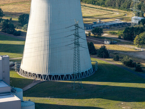 Aerial view of the cooling tower at Janschwalde Power Plant, a facility transitioning from coal, surrounded by industrial infrastructure and green landscape in Peitz, Brandenburg, Germany.