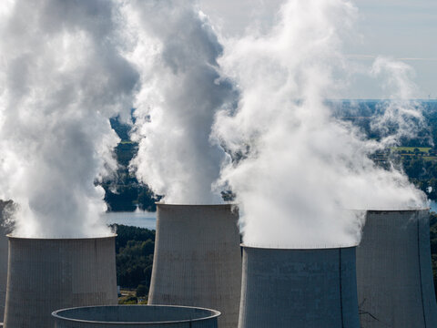Aerial view of the Janschwalde Power Station cooling towers emitting steam, showcasing the industrial landscape near Peitz, Brandenburg, Germany.