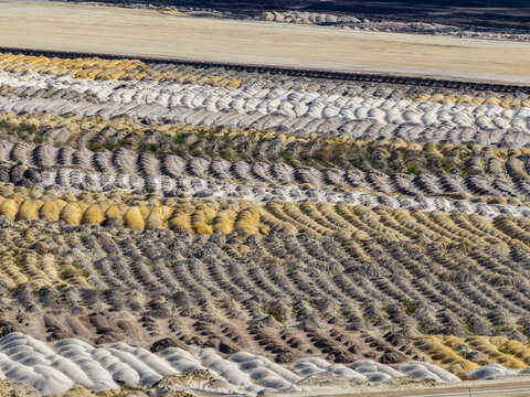 Aerial view of Tagebau Welzow-Sud brown coal open-pit mine showing rows of excavated earth and soil mounds in Spremberg, Brandenburg, Germany.