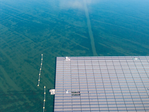 Aerial view of the floating solar farm on Cottbuser Ostsee, a former open pit mine, showing solar panels on water with repair works in progress in Cottbus, Brandenburg, Germany.