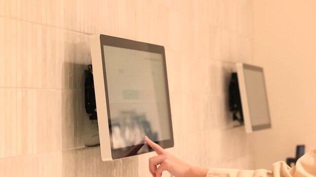 Shopper taps kiosk screen while browsing inside store aisle