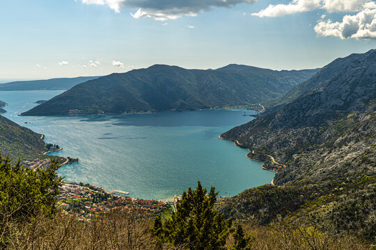 Spectacular panoramic view over the turquoise Bay of Kotor, coastal settlements and steep limestone mountains in Montenegro. Scenic Adriatic landscape photographed from a high mountain viewpoint.