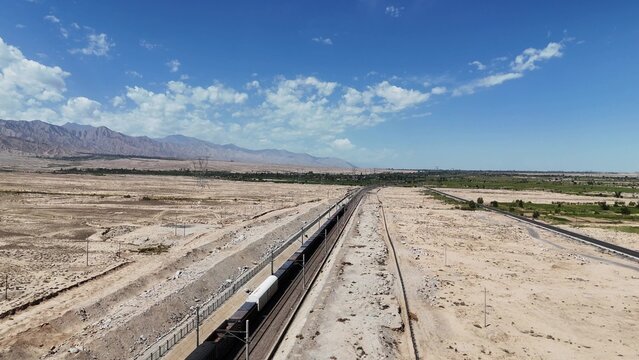 winding railway tracks traversing the desert landscape under blue sky