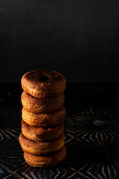 Stack of cinnamon donuts on a dark surface 