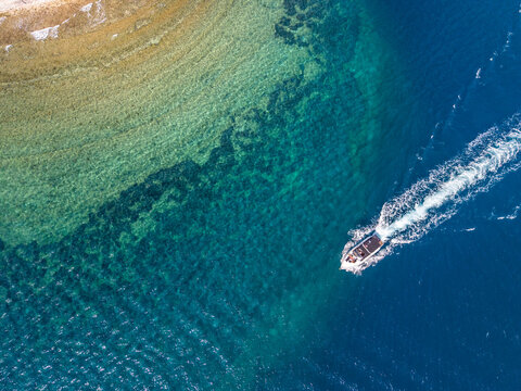Aerial view of motorboat on turquoise sea near Kalami, Corfu, Ionian Islands, Greece