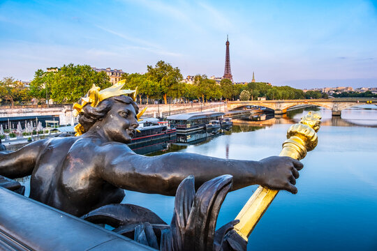 Bronze nymph sculpture on Pont Alexandre III with River Seine and Eiffel Tower beyond, Paris, France