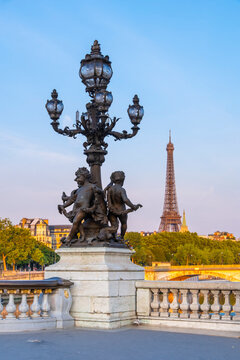 Ornate lamp post with cherub sculptures on Pont Alexandre III with Eiffel Tower beyond, Paris, France