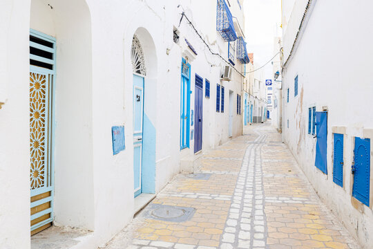 Narrow whitewashed alley with blue doors and windows, Kairouan, Tunisia