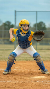 Young Female Softball Catcher Ready to Throw Ball on Field