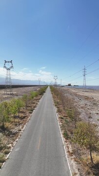 straight road and transmission towers next to tower solar thermal power station