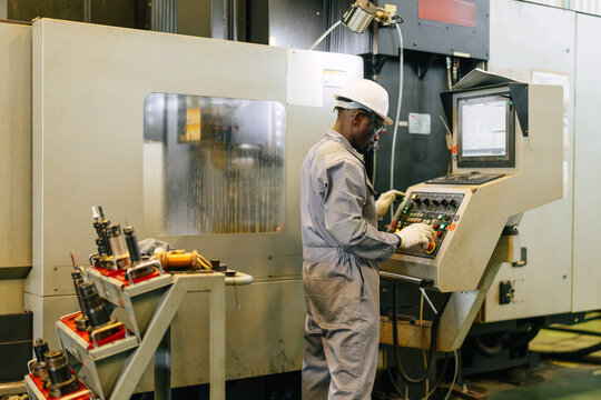 Engineer Operating CNC Machine in Factory Checking Industrial Manufacturing Process Control