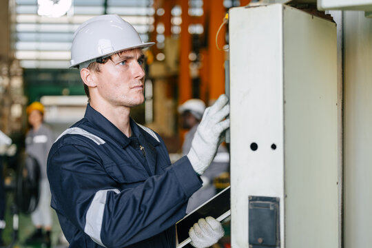 Technician Worker Male Engineer Operating Control CNC Machine on Panel in Metal Plant Factory