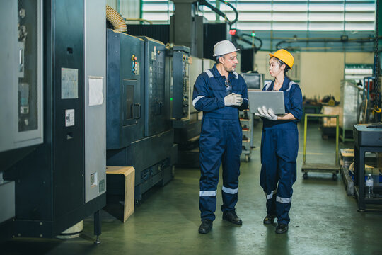 Senior Supervisor Engineer and Young Female Worker Working Together Factory Machine Training.