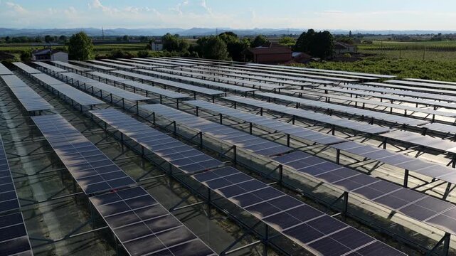 Aerial view of rows of solar panels installed in a field in Faenza, Emilia-Romagna, Italy.
